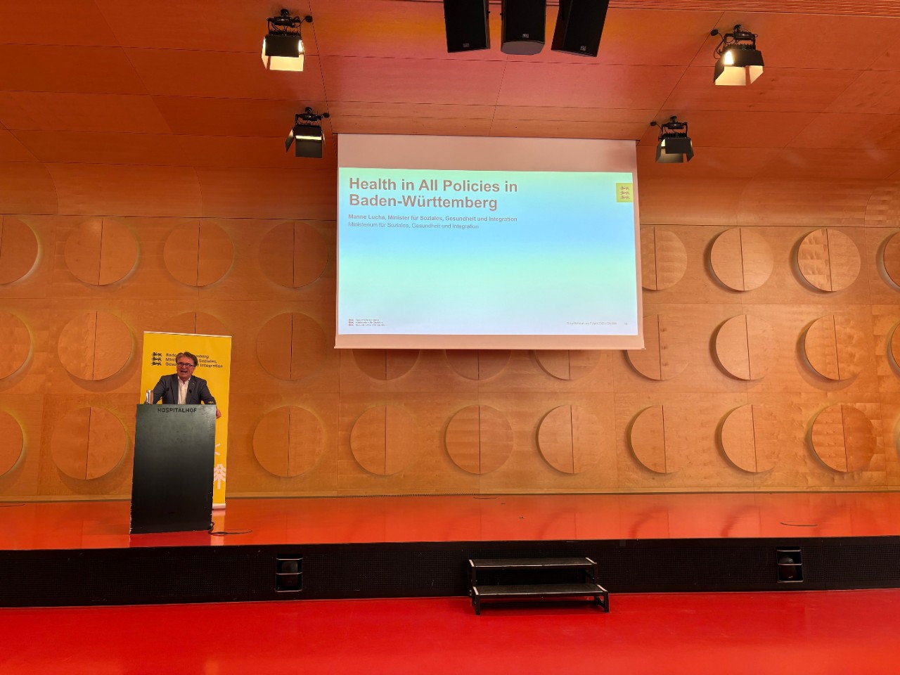 Health in All Policies - 1 Mann am Rednerpult stehend