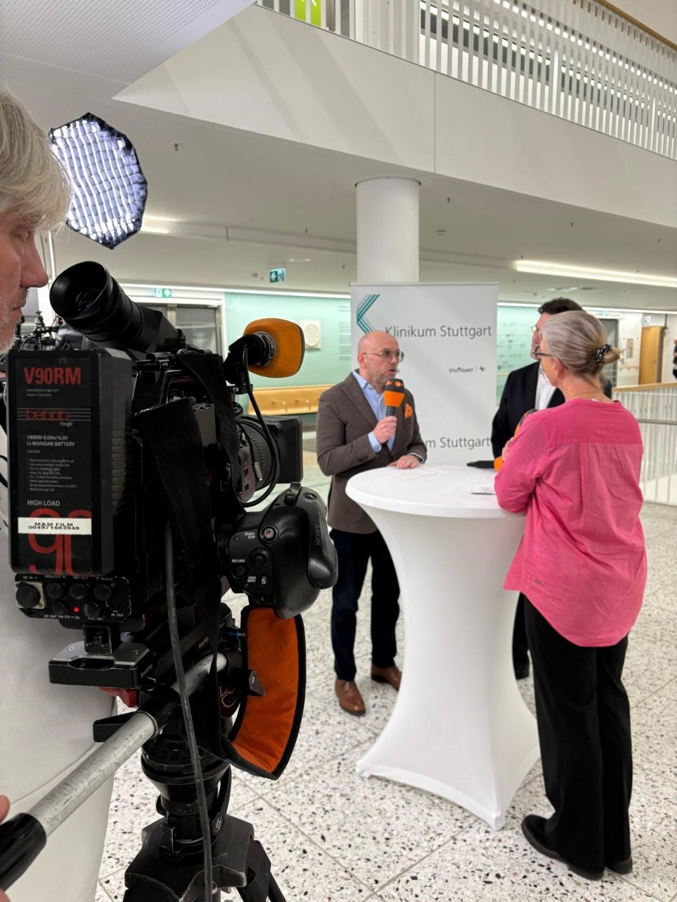 ZDF-Dreh im Klinikum Stuttgart. 1 Frau und 2 Männer vor einem Kameramann stehend
