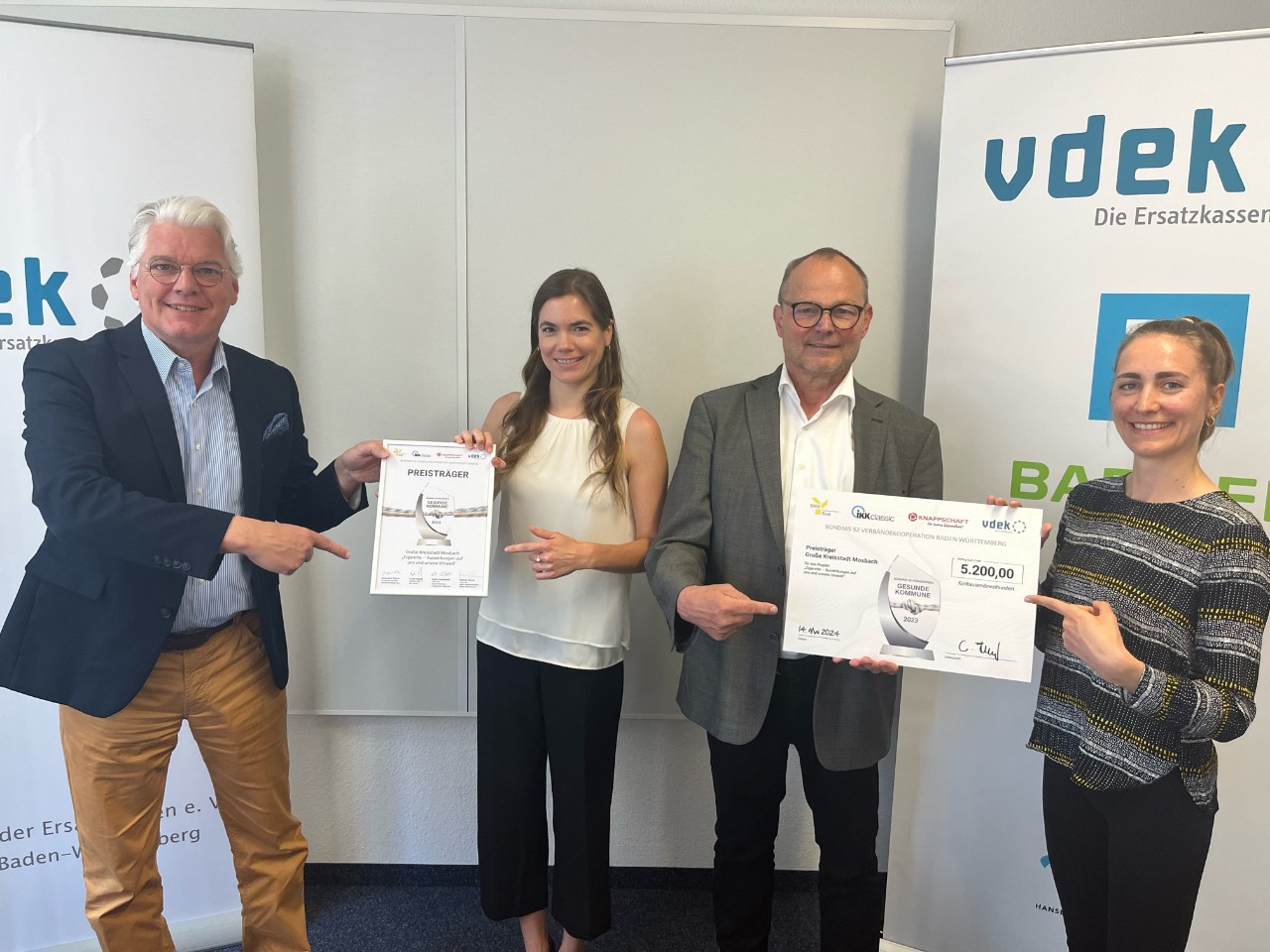 Förderpreis "Gesunde Kommune" 2 Frauen und 2 Männer mit Auszeichnung stehend Förderpreis "Gesunde Kommune" 2 Frauen und 2 Männer mit Auszeichnung stehend