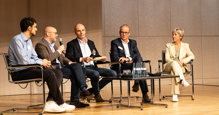 1 Frau und 4 Männer in einer Diskussion sitzend 1 Frau und 4 Männer in einer Diskussion sitzend