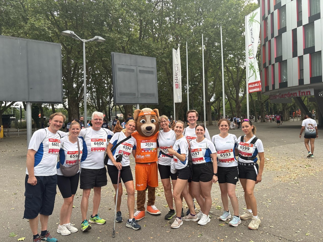 B2Run, 10 Frauen und Männer mit Maskottchen in der Gruppe stehend