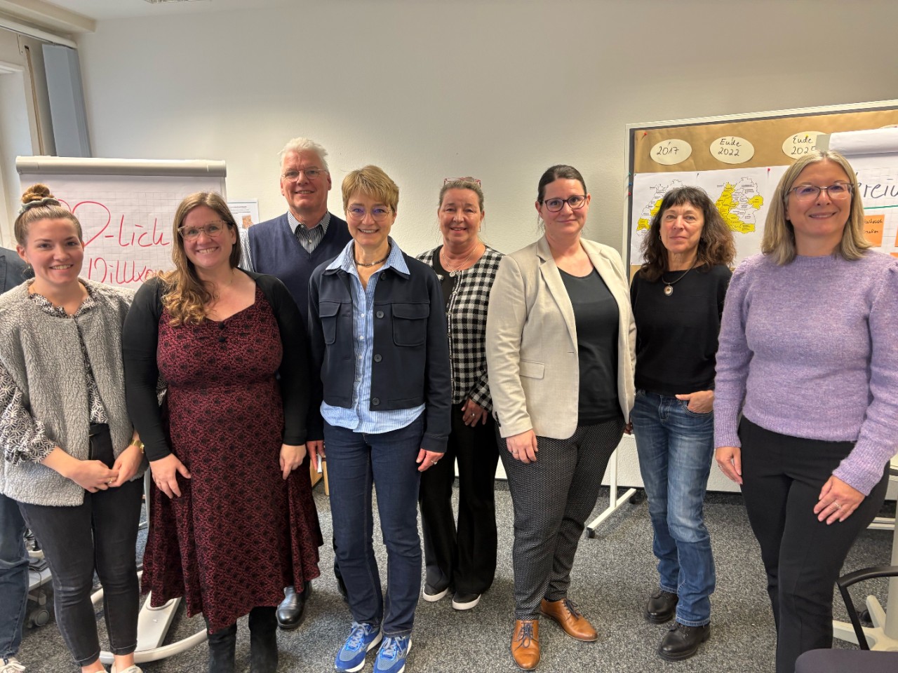 7 Frauen und 1 Mann stehend