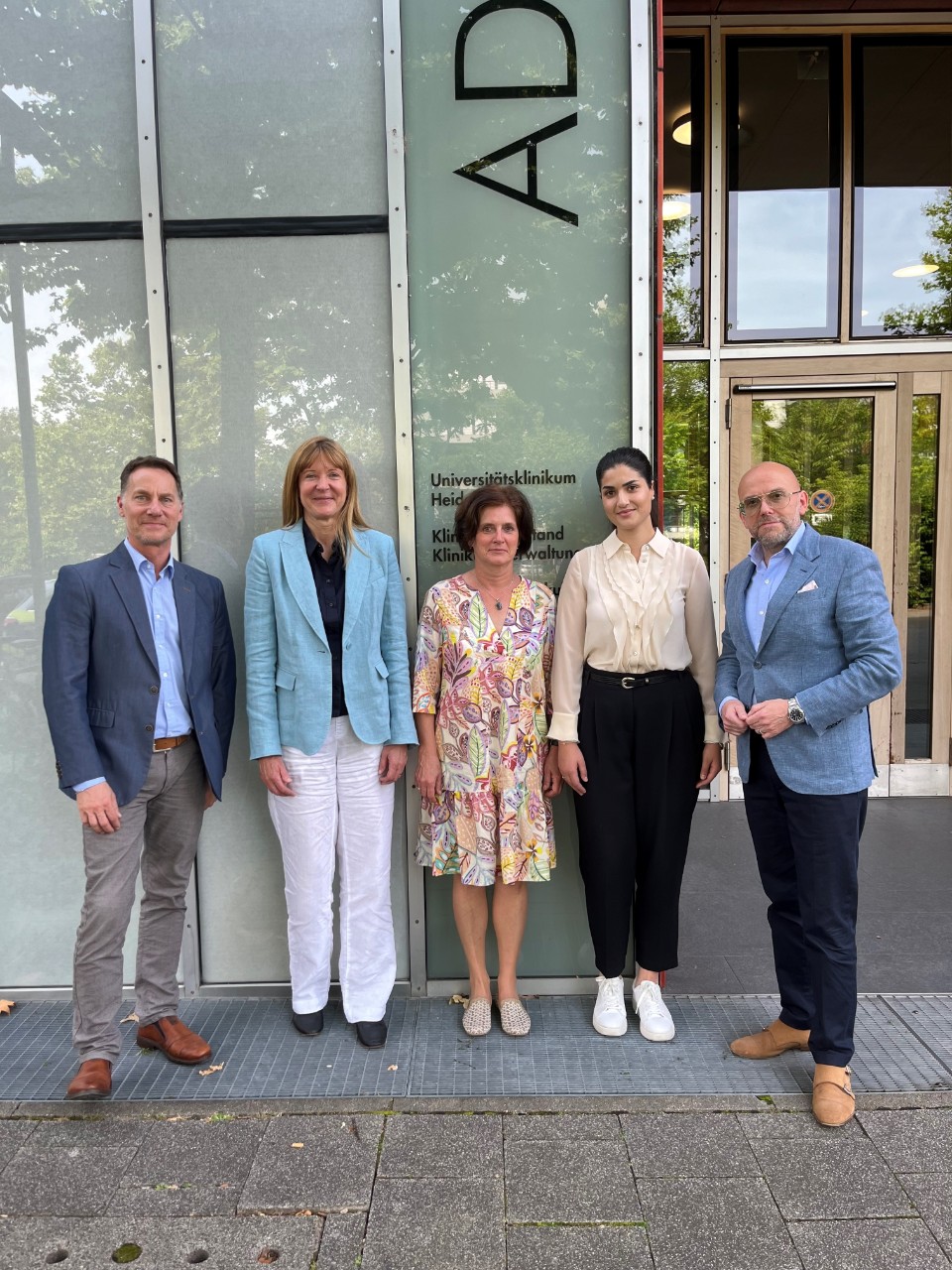 Besuch der Uniklinik Heidelberg am 18.6.24, 3 Frauen und 2 Männer in der Gruppe stehend Besuch der Uniklinik Heidelberg am 18.6.24, 3 Frauen und 2 Männer in der Gruppe stehend