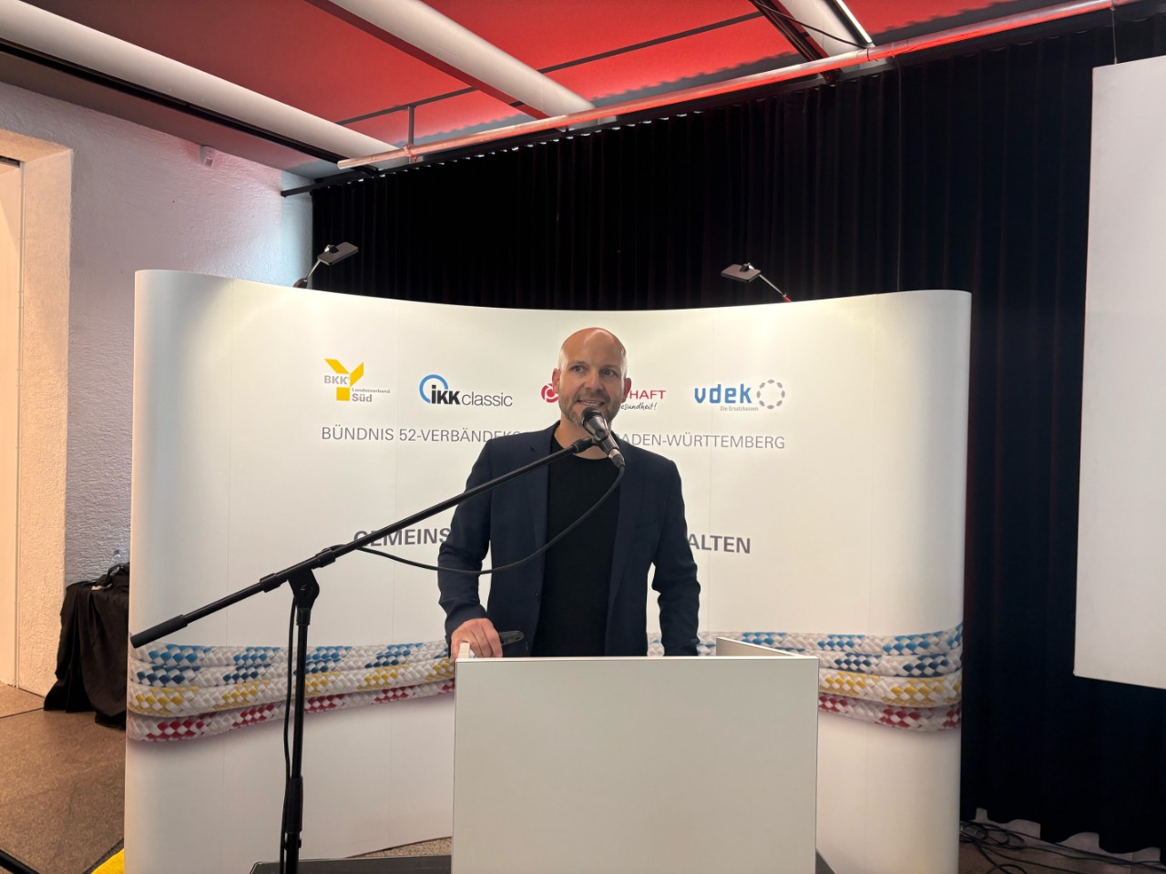 16. Juni 2026, Empfang, 1 Mann am Rednerpult stehend