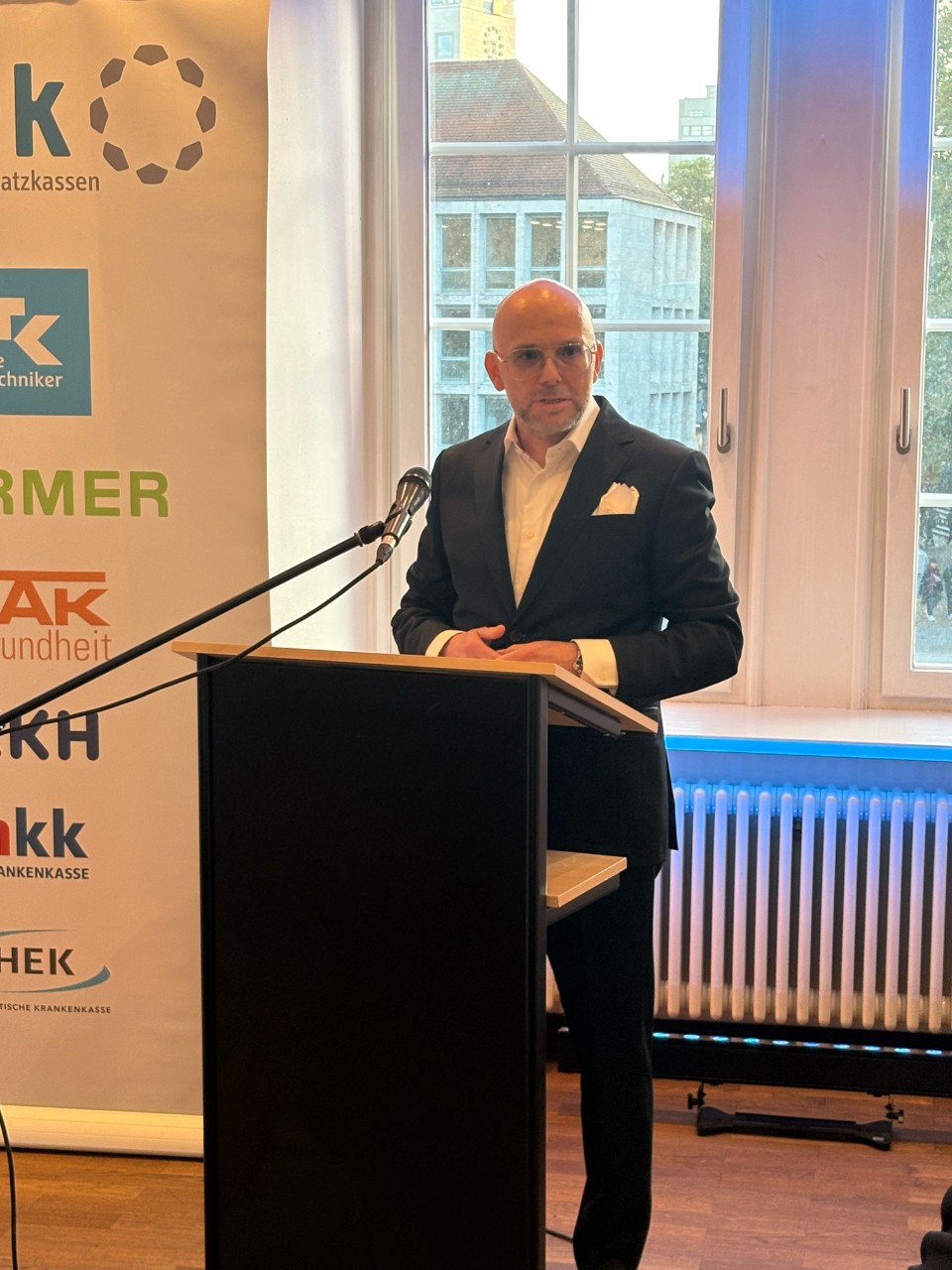 1 Mann am Rednerpult stehend