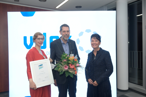 zwei Frauen und ein Mann mit Blumenstrauss in der Hand