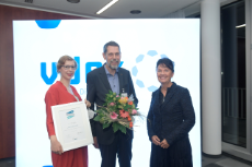 zwei Frauen und ein Mann mit Blumenstrauss in der Hand