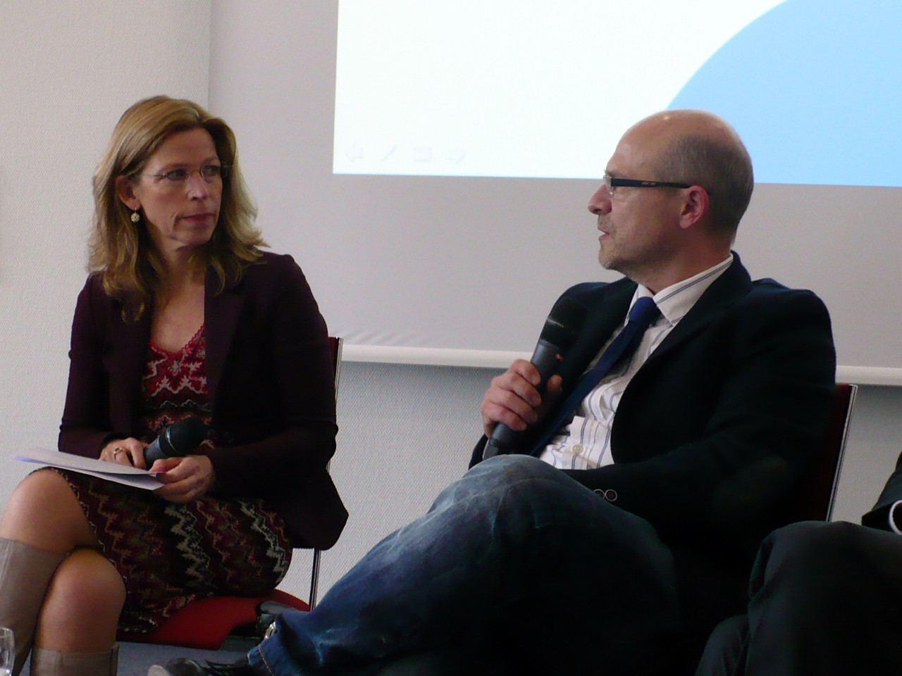 Moderatorin Beate Hoffmann spricht mit Priv.-Doz. Dr. Carsten Oberhoff auf dem Podium.