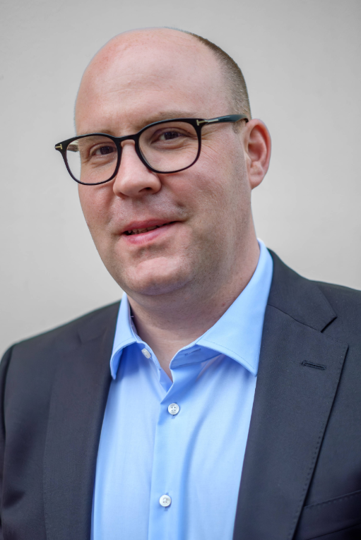 Porträt eines Mannes im blauen Hemd mit Brille