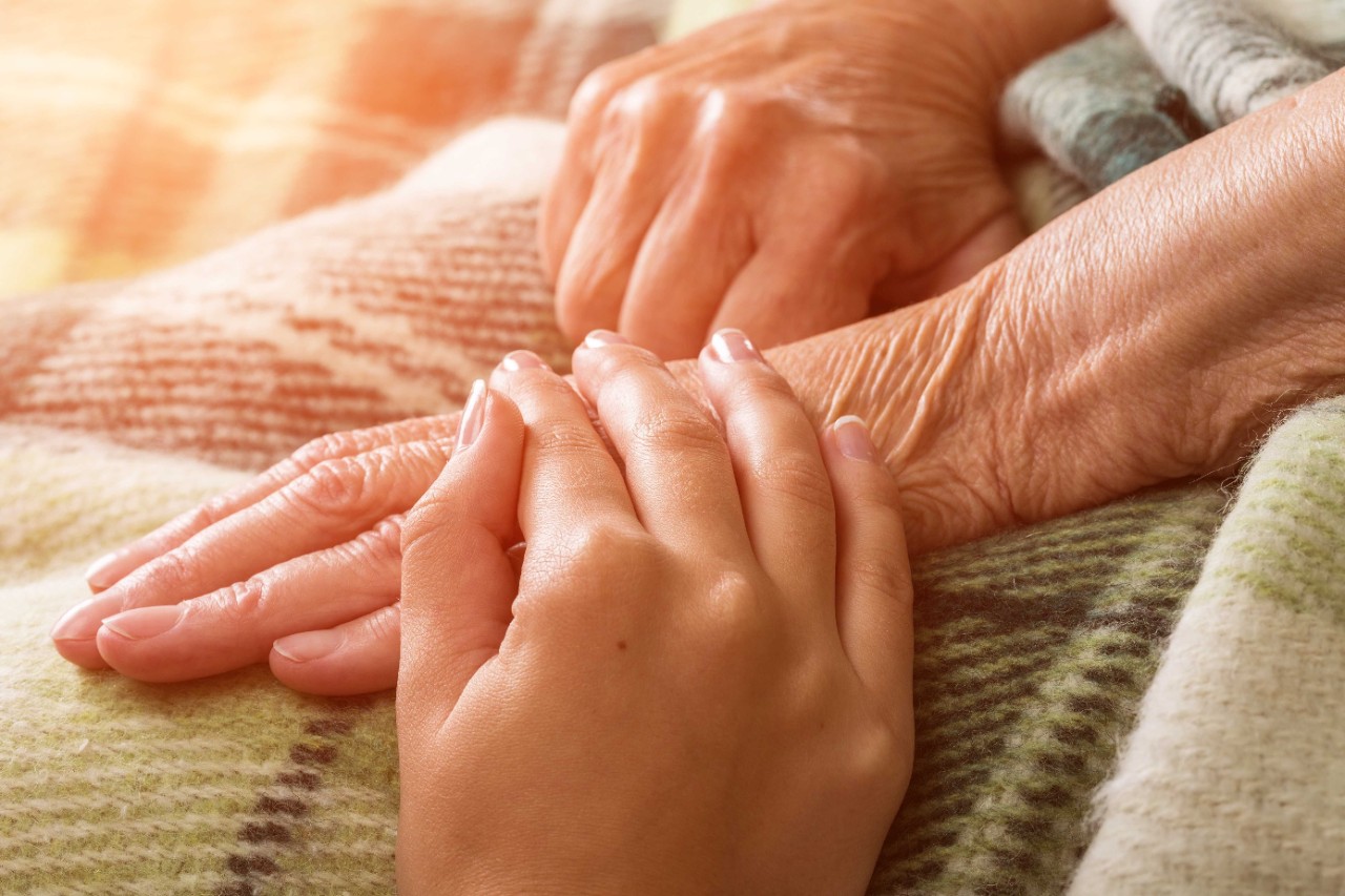 Alte Hände werden von junger Hand berührt