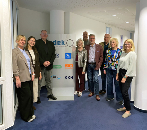 Gruppe von fünf Frauen und vier Männern vor dem vdek-Aufsteller