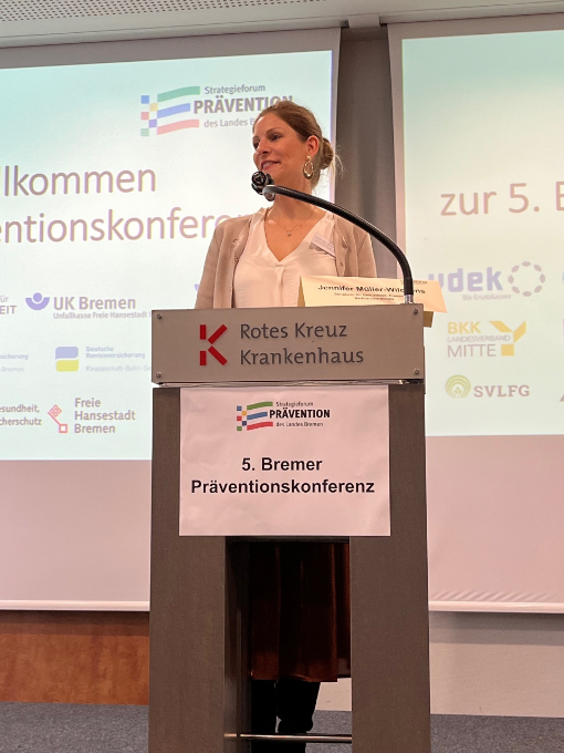 Frau am Pult, im Hintergrund Präsentation Frau am Pult, im Hintergrund Präsentation