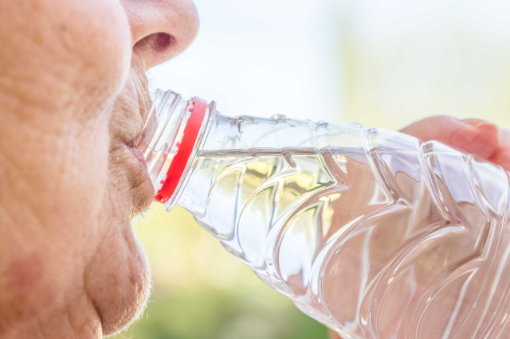 Ältere Frau trinkt aus Wasserflasche