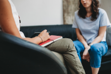 Eine Frau im Gespräch mit einer Therapeutin bei einer Psychotherapie-Sitzung