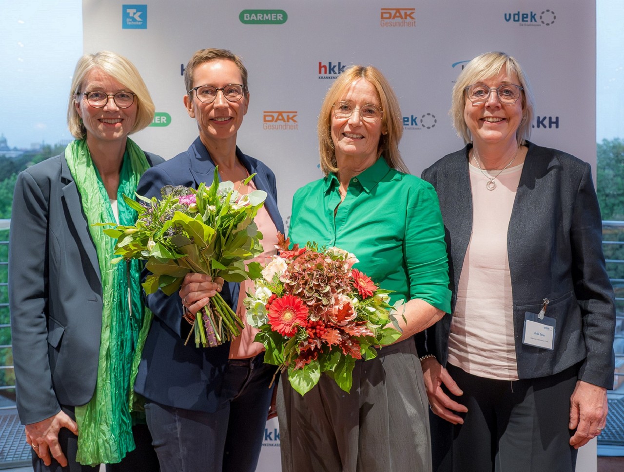 Zwei Frauen mit Blumensträußen eingerahmt von zwei weiteren Frauen