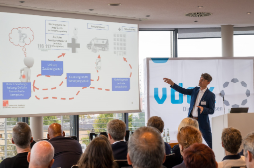 Mann erklärt Powerpoint-Folie bei Veranstaltung