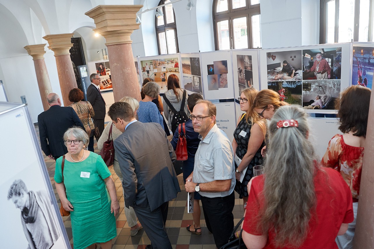 G&auml;ste der Fotoausstellung betrachten die Fotografien