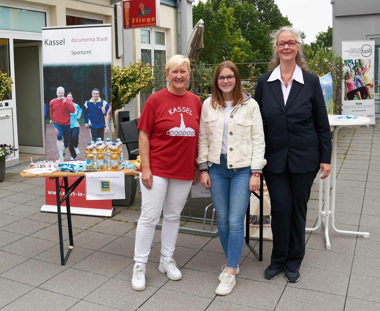 drei Frauen vor einem Informationstisch drei Frauen vor einem Informationstisch