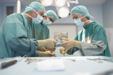 Three Surgeons At Work In Operating Theatre