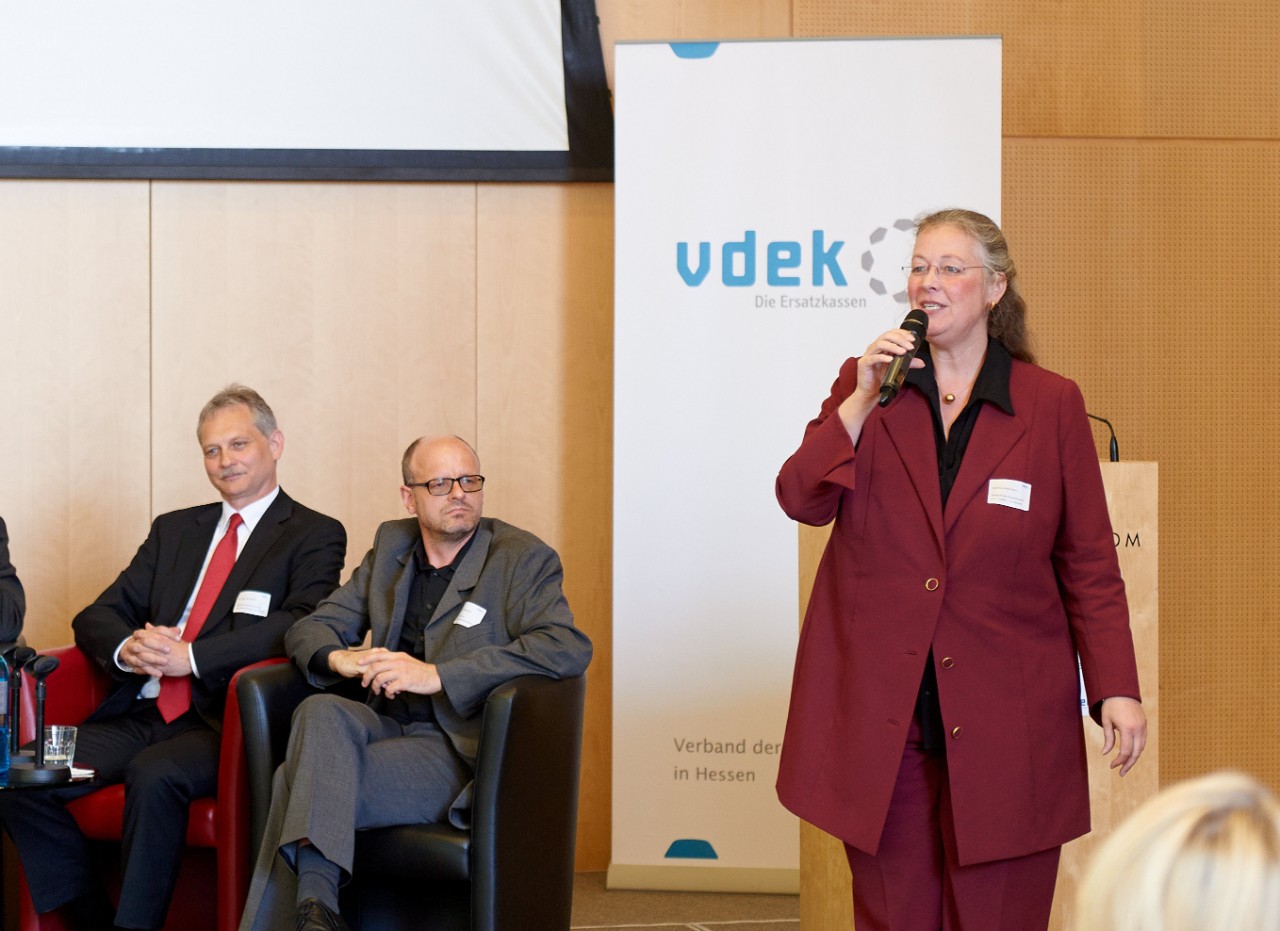 Claudia Ackermann, Leiterin der vdek-Landesvertretung Hessen, hält ein Mikrofon und spricht