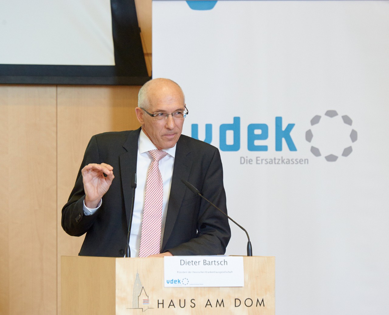 Dieter Bartsch, Präsident der Hessischen Krankenhausgesellschaft, steht am Rednerpult und spricht
