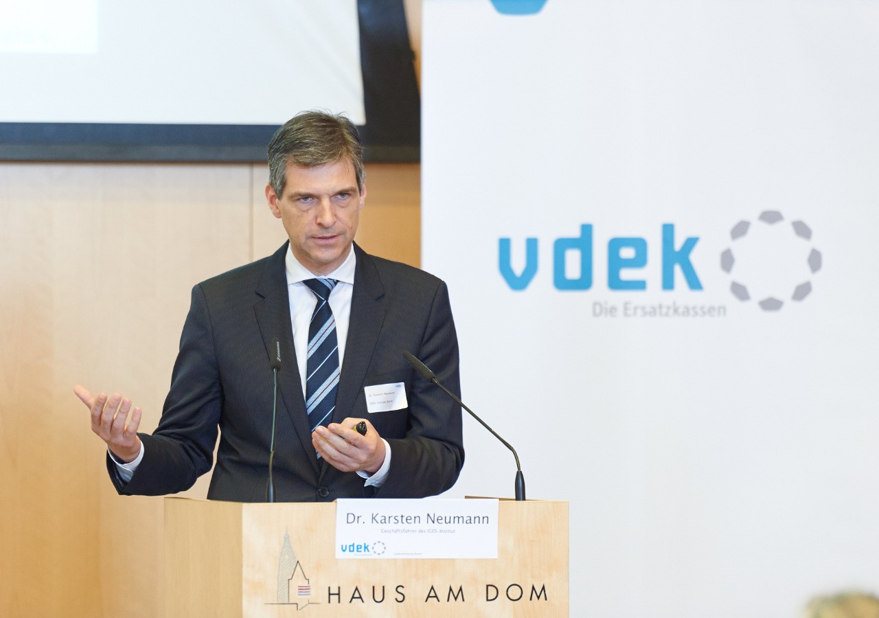 Dr. Karsten Neumann, Geschäftsführer des IGES-Instituts, steht am Rednerpult und spricht