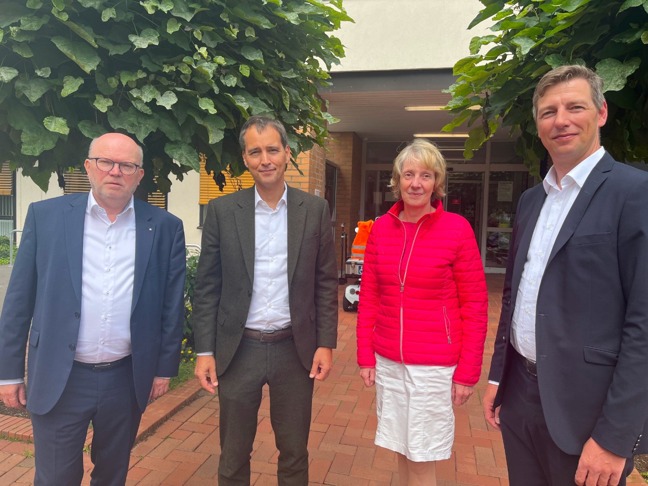 Vier Personen stehen vor dem Eingang eines Regionalen Gesundheitszentrums Vier Personen stehen vor dem Eingang eines Regionalen Gesundheitszentrums