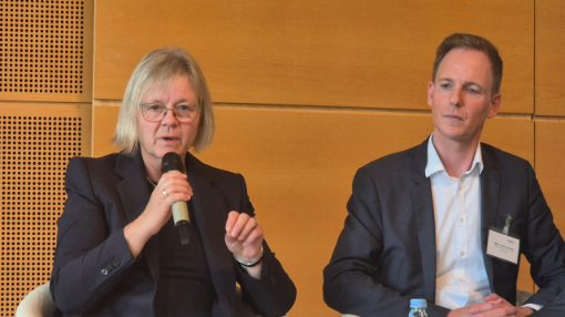 Zwei Menschen sitzen auf einer Bühne und diskutieren
