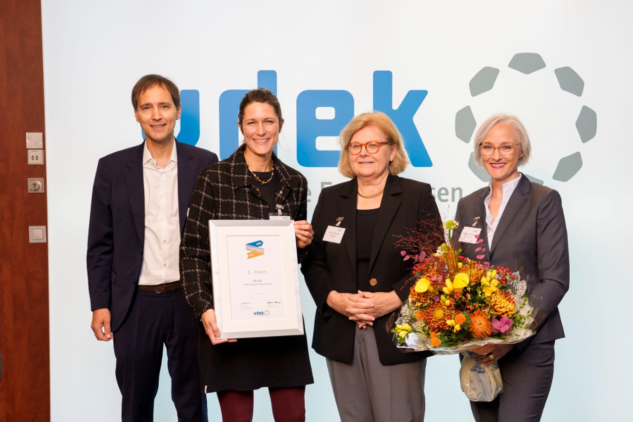 Drei Frauen und ein Mann stehen auf einer Bühne bei einer Preisverleihung