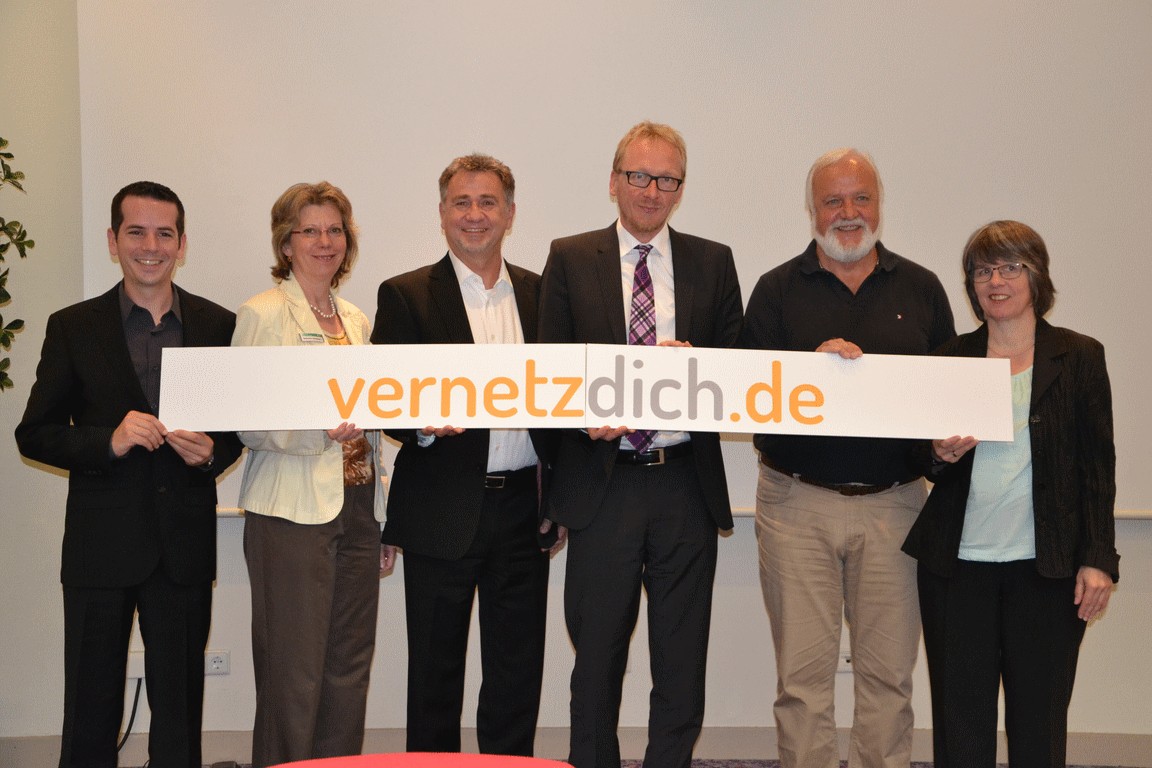 Zwei Frauen und vier Männer mit dem Schild vernetzdich.de Zwei Frauen und vier Männer mit dem Schild vernetzdich.de