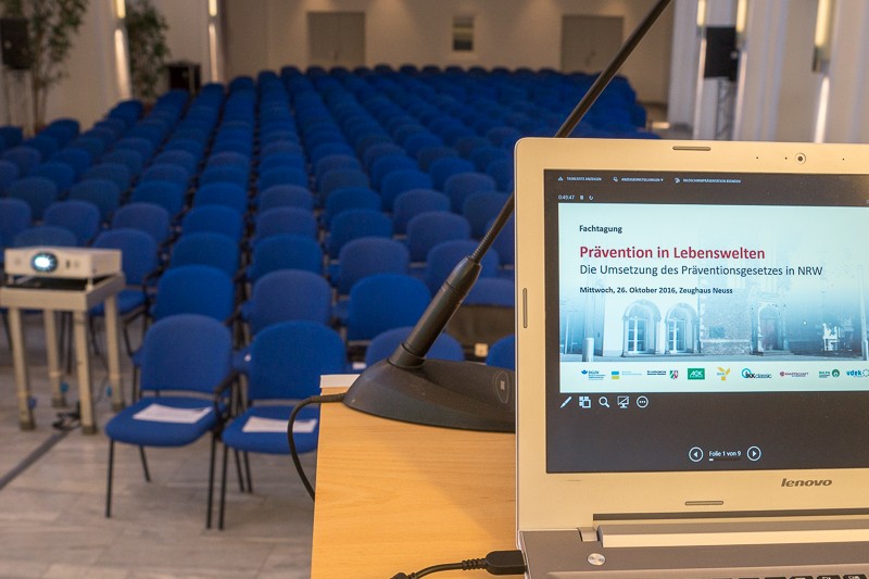 Blick in den leeren Veranstaltungsraum mit Laptop im Vordergrund