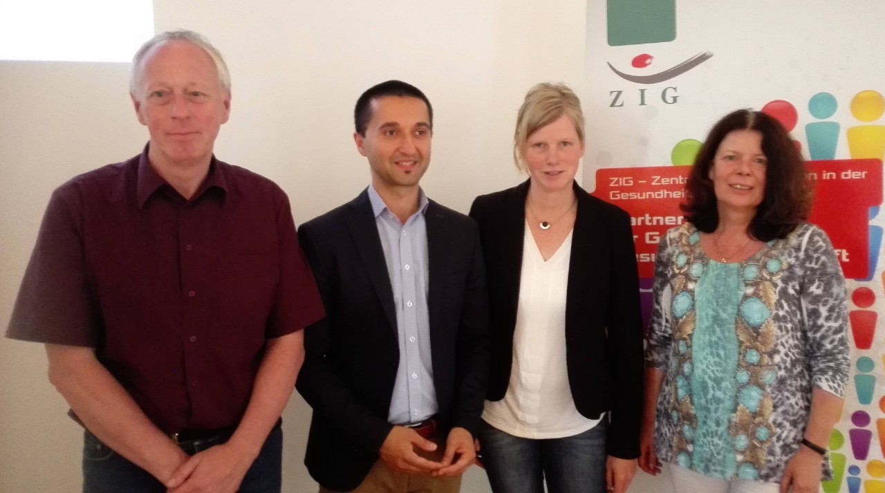 Sigrid Averesch-Tietz mit drei weiteren Personen vor dem Logo des ZTG