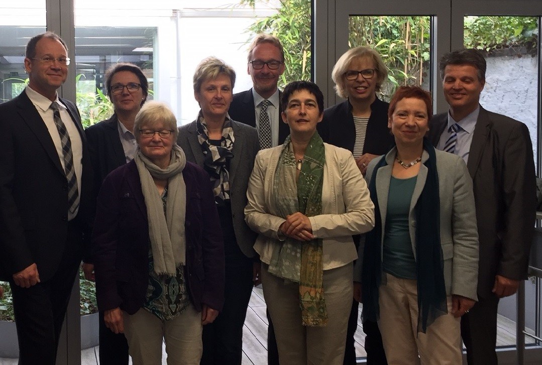 Acht Menschen schauen zusammen mit NRW Gesundheitsministerin Barbara Steffens in die Kamera