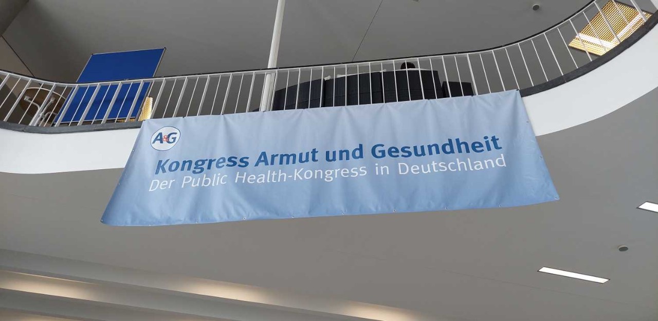 Am Geländer befestigtes Banner mit der Aufschrift "Kongress Armut und Gesundheit"
