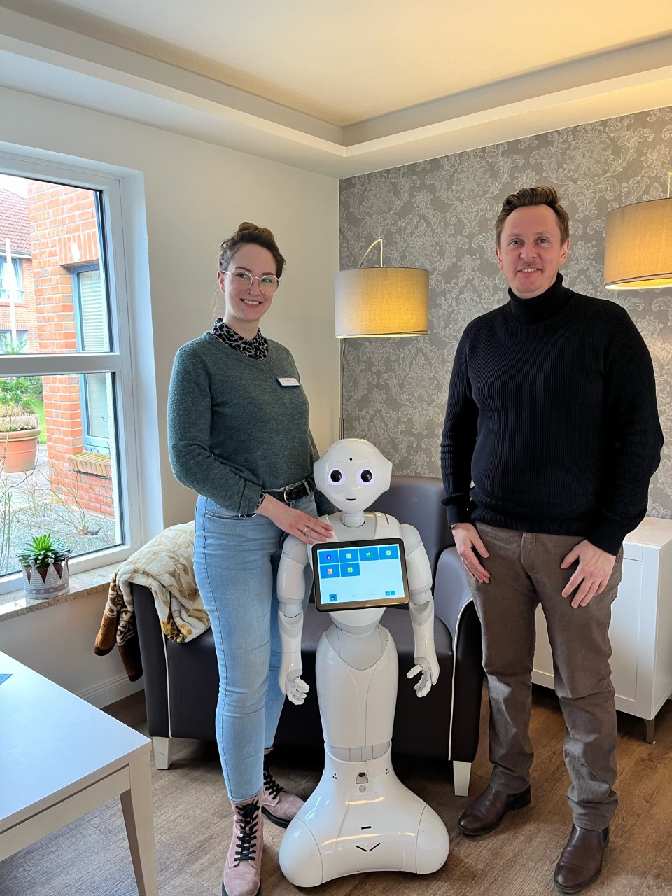 Pflegekraft Tabea Kabus in der Einrichtung am See der Diakonie in Fockbek mit Ringo Schoepke (vdek NRW) und Roboter Piet