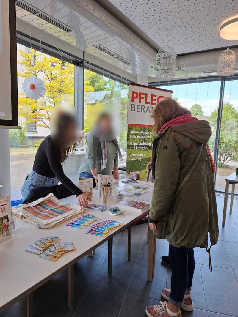 Stand zur Pflegeberatung mit zwei Beraterinnen und einer Interessierten