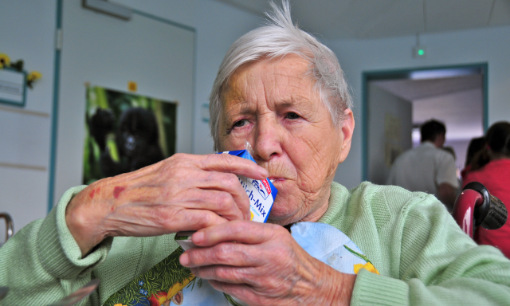 Alte Frau trinkt aus Tetrapack