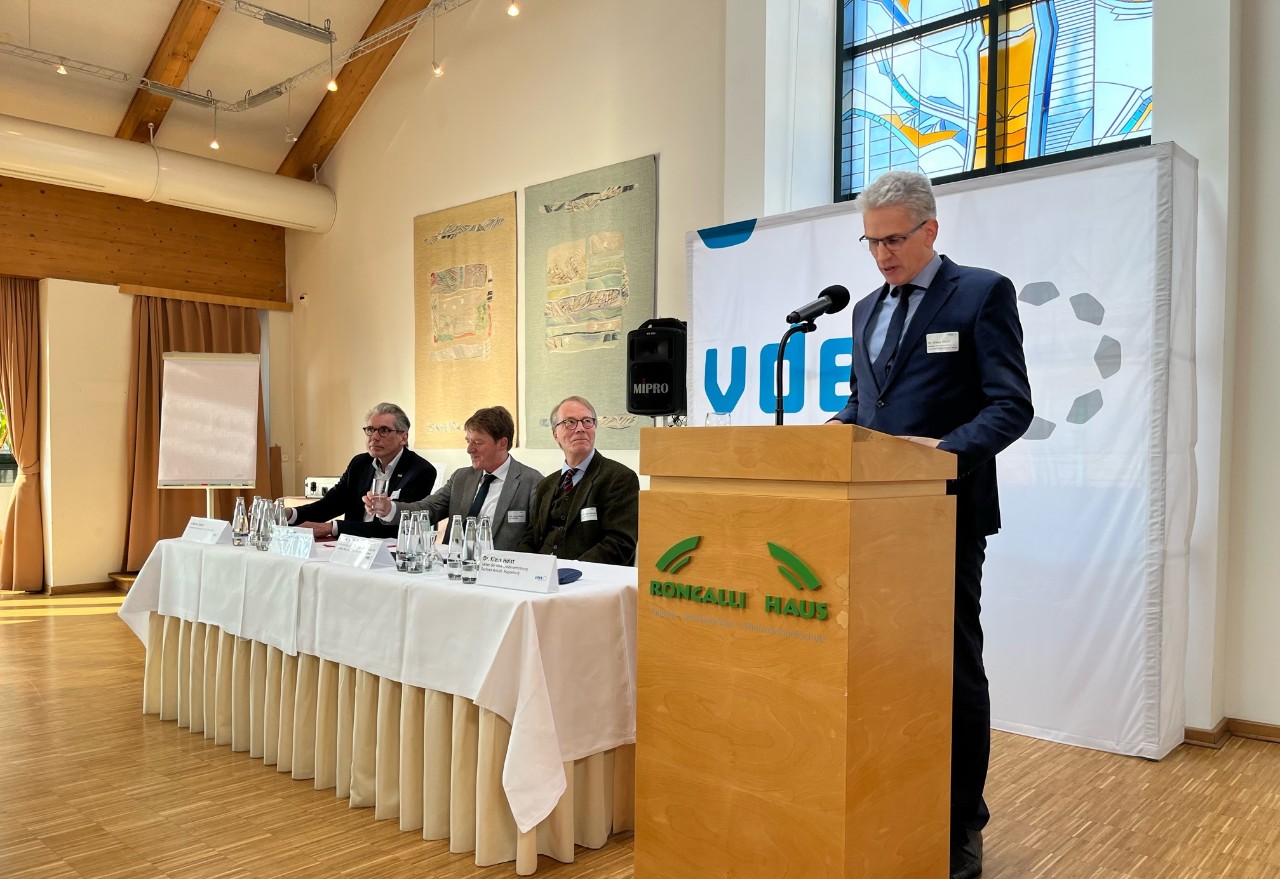 Dr. Klaus Holst er&ouml;ffnet das Symposium und begr&uuml;&szlig;t die Referenten Andreas Storm (Vorstandsvorsitzender der DAK-Gesundheit), Prof. Ulrich Becker (Max-Planck-Institut), Prof. Stefan Korioth (Ludwig-Maximilians-Universit&auml;t M&uuml;nchen) (v. l. n. r.) 