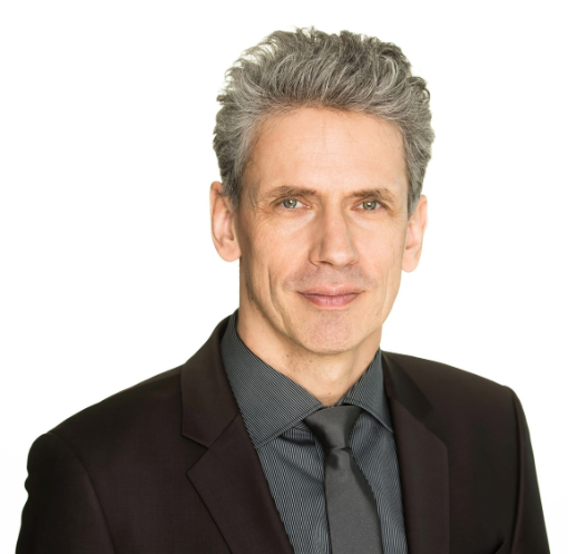 Portraitbild eines Mannes im schwarz-grauen Anzug