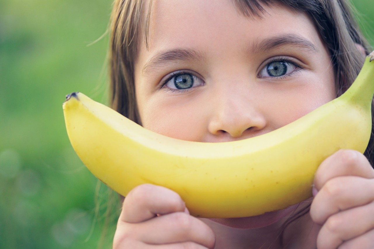 Kind mit Banane vor dem Gesicht