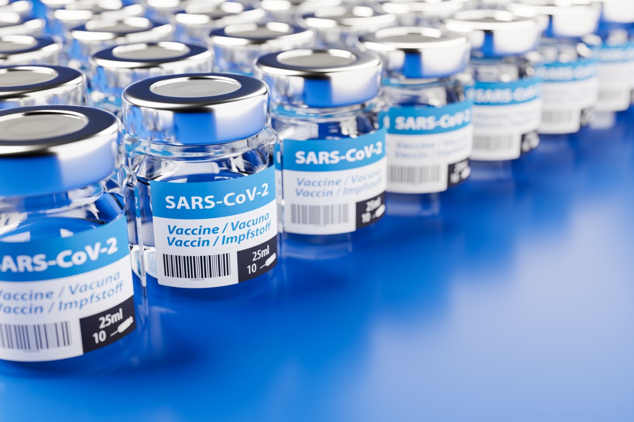 Concept for availability of enough vaccine against new corona virus SARS-CoV-2: Rows of glass container of vaccination. The word vaccination in English, Spanish, French and German on the label