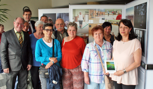 Stehende Männer und Frauen hinter einem Plakattafel in einem Raum Stehende Männer und Frauen hinter einem Plakattafel in einem Raum