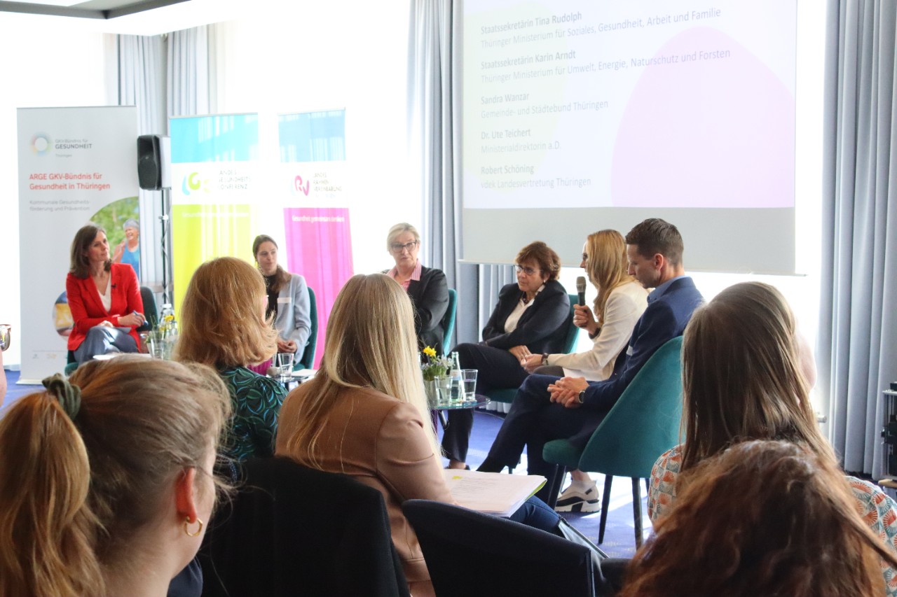 F&uuml;nf Menschen sitzen vor Publikum