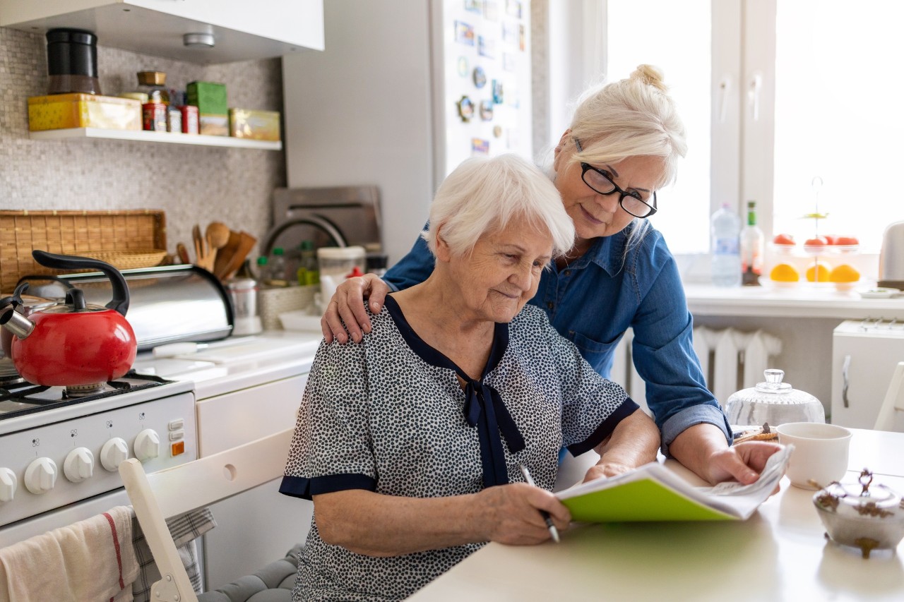 Mutter und Tochter unterstützt beim Papierkram, neu Mutter und Tochter unterstützt beim Papierkram, neu