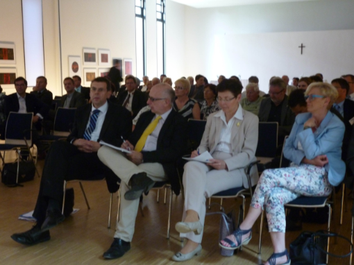 Sitzende Menschen in einem bestuhlten Veranstaltungsraum