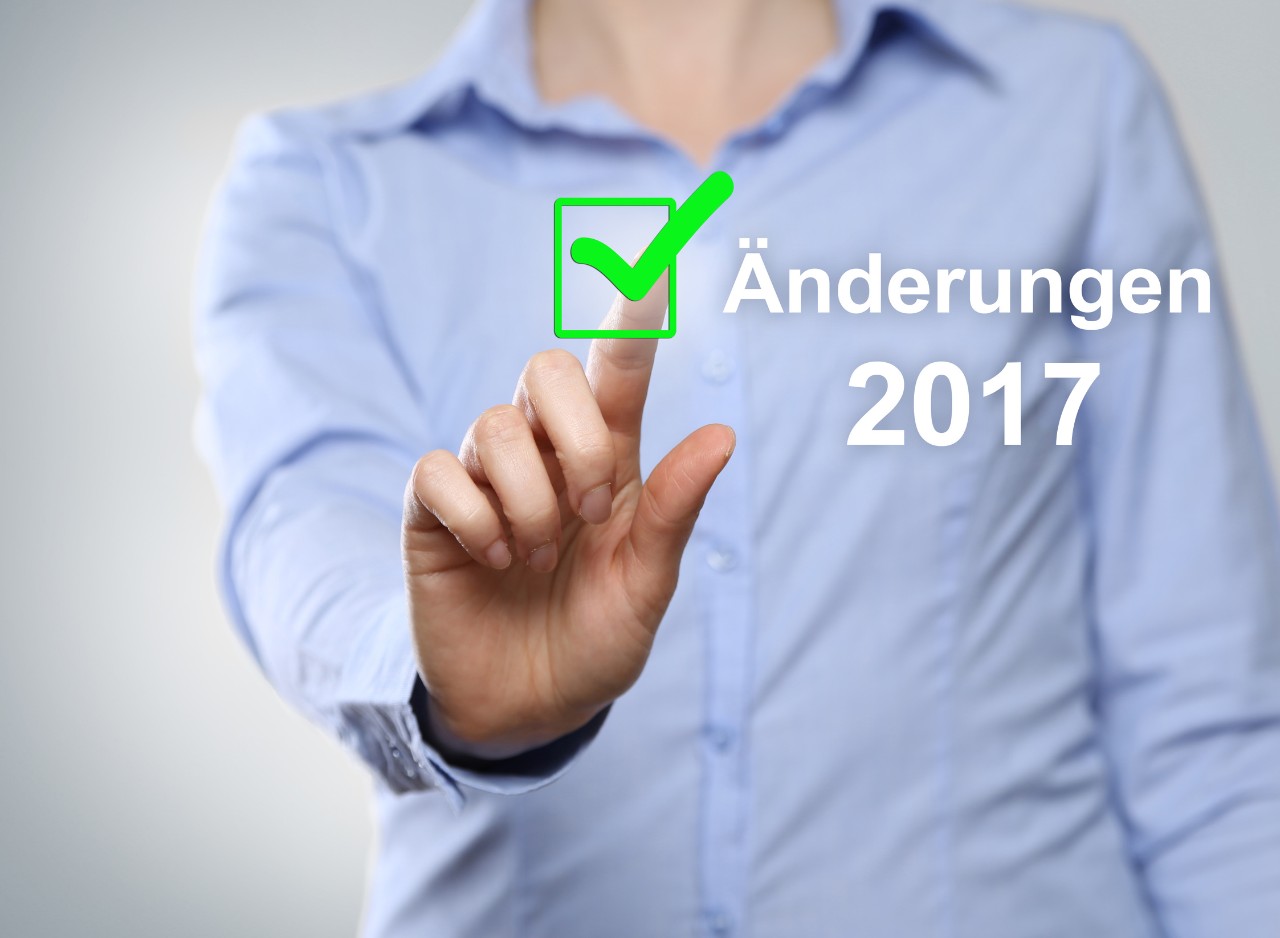 Mann im hellblauen Hemd tippt auf grüne Checkbox, neben der "Änderungen 2017" steht 