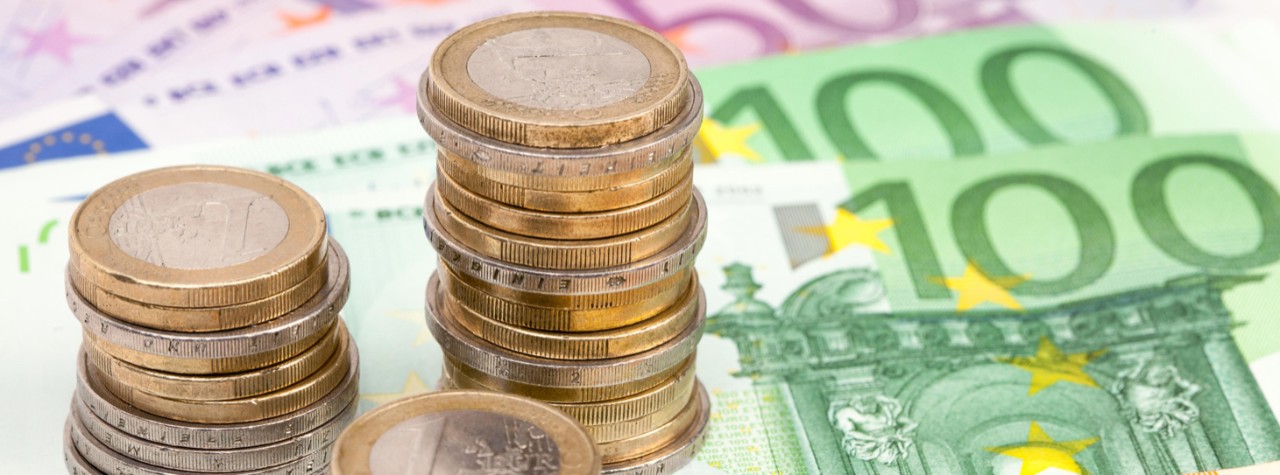 Euro-Scheine und gestapelte Euro-Münzen