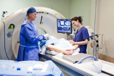 Ein Arzt und eine Krankenschwester untersuchen einen Patienten mit einem MRI-Gerät (Magnetic Resonance Imaging)