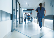 Sanitäter schieben eine Trage durch den Flur einer Notaufnahme