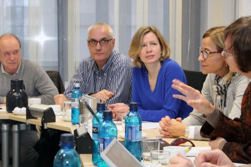 Ausschnitt aus einer Konferenz oder Diskussionsrunde, mehrere Personen sitzen diskutierend an Tischen